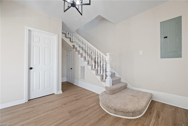 10 Church St, Windsor, VA 23487 - stairway with electric panel, wood finished floors, and a chandelier