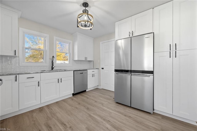 10 Church St, Windsor, VA 23487 - kitchen with appliances with stainless steel finishes, backsplash, light wood finished floors, light stone counters, and a chandelier