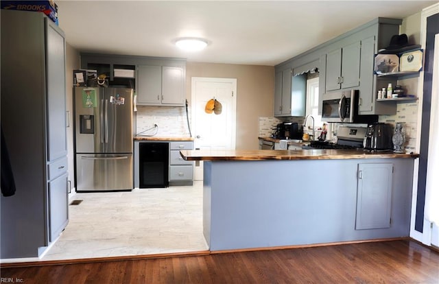4225 Terry Dr, Chesapeake, VA 23321 - kitchen with stainless steel appliances, a peninsula, backsplash, light wood-style floors, and open shelves