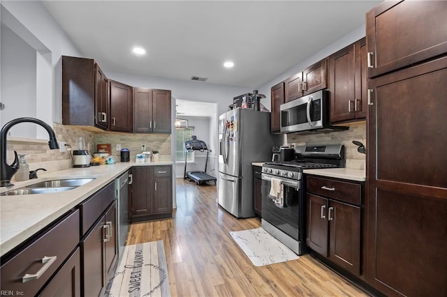 4041 Hargrove Lndg, Suffolk, VA 23435 - kitchen with stainless steel appliances, backsplash, light wood-style flooring, dark brown cabinetry, and recessed lighting