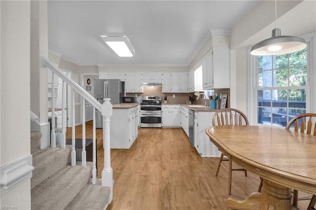 605 Hollygate Ln, Chesapeake, VA 23322 - kitchen featuring appliances with stainless steel finishes, white cabinets, under cabinet range hood, light wood-style floors, and light countertops