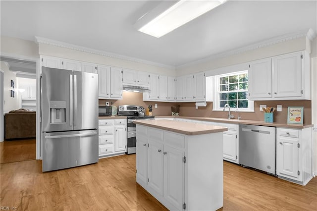 605 Hollygate Ln, Chesapeake, VA 23322 - kitchen featuring stainless steel appliances, under cabinet range hood, light wood-style floors, white cabinetry, and crown molding
