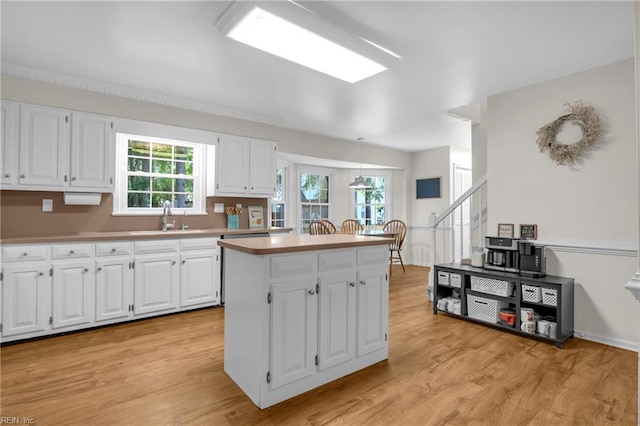 605 Hollygate Ln, Chesapeake, VA 23322 - kitchen featuring light wood-style floors, a kitchen island, white cabinetry, and light countertops