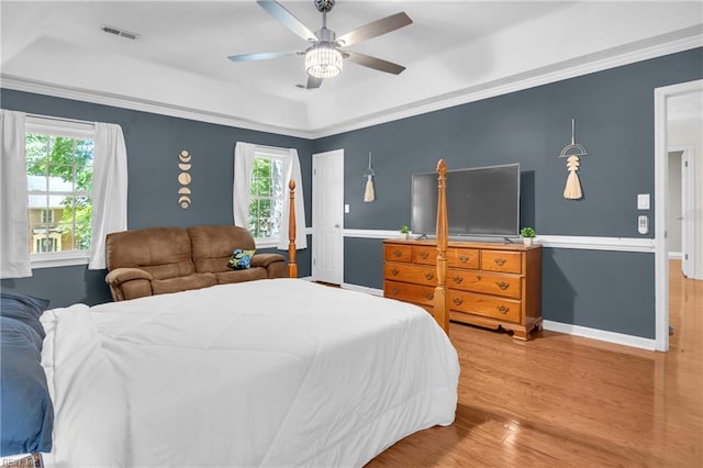 605 Hollygate Ln, Chesapeake, VA 23322 - bedroom with multiple windows, wood finished floors, a ceiling fan, a tray ceiling, and ornamental molding