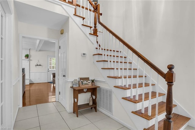 605 Hollygate Ln, Chesapeake, VA 23322 - stairs featuring tile patterned floors, beamed ceiling, wainscoting, and a decorative wall