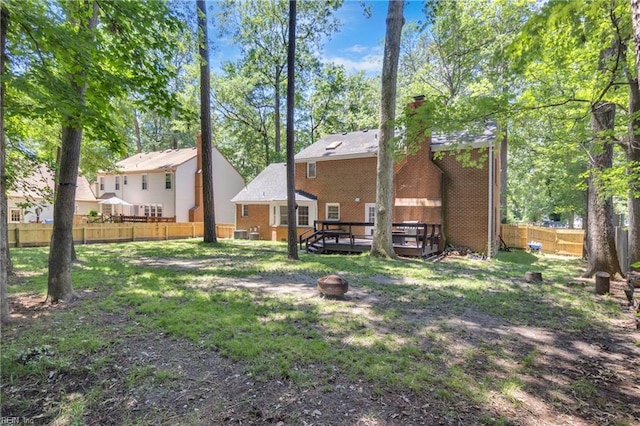 605 Hollygate Ln, Chesapeake, VA 23322 - rear view of house with a fenced backyard, brick siding, a chimney, a deck, and an outdoor fire pit