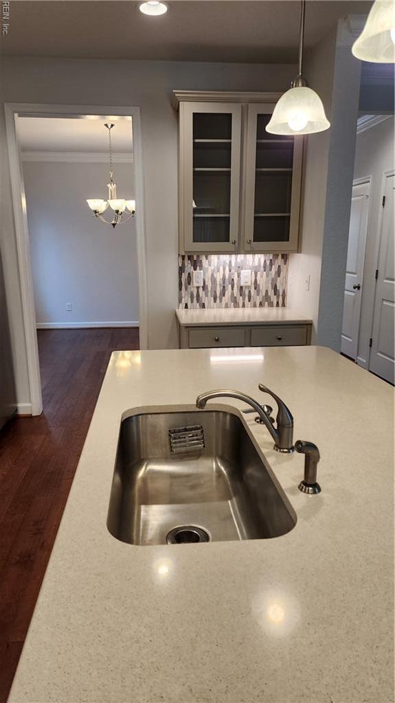 217 Wineberry Way, Yorktown, VA 23692 - kitchen with crown molding, a chandelier, tasteful backsplash, light countertops, and glass insert cabinets