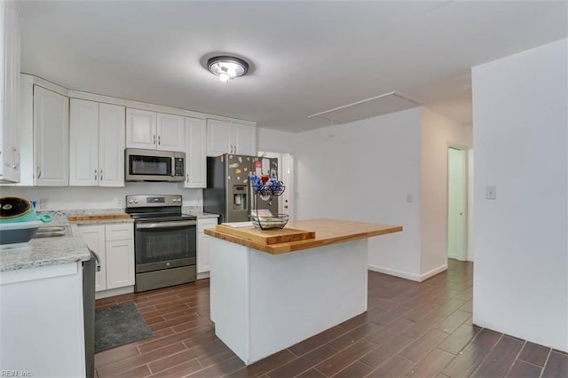 540 Draper Dr, Norfolk, VA 23505 - kitchen with appliances with stainless steel finishes, wood tiled floors, white cabinets, a center island, and wood counters