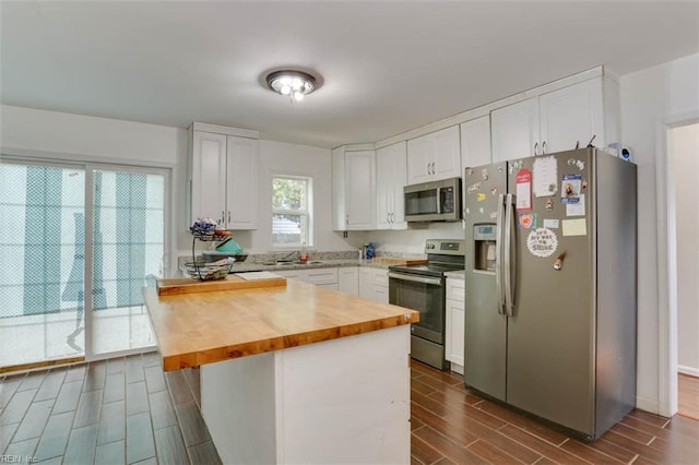 540 Draper Dr, Norfolk, VA 23505 - kitchen with appliances with stainless steel finishes, butcher block counters, a peninsula, wood finish floors, and white cabinets