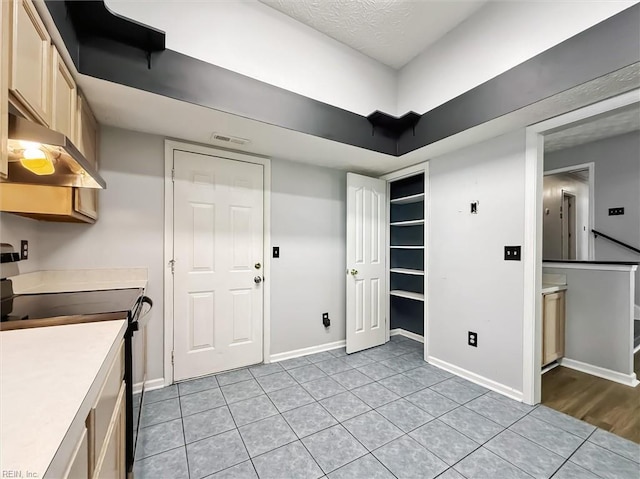 100 Peacepipe Pl, Williamsburg, VA 23185 - kitchen featuring electric stove, under cabinet range hood, light countertops, light tile patterned floors, and a textured ceiling