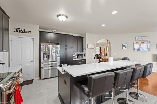 1949 Lemonwood Rd, Chesapeake, VA 23323 - kitchen featuring appliances with stainless steel finishes, arched walkways, a breakfast bar, light countertops, and open floor plan