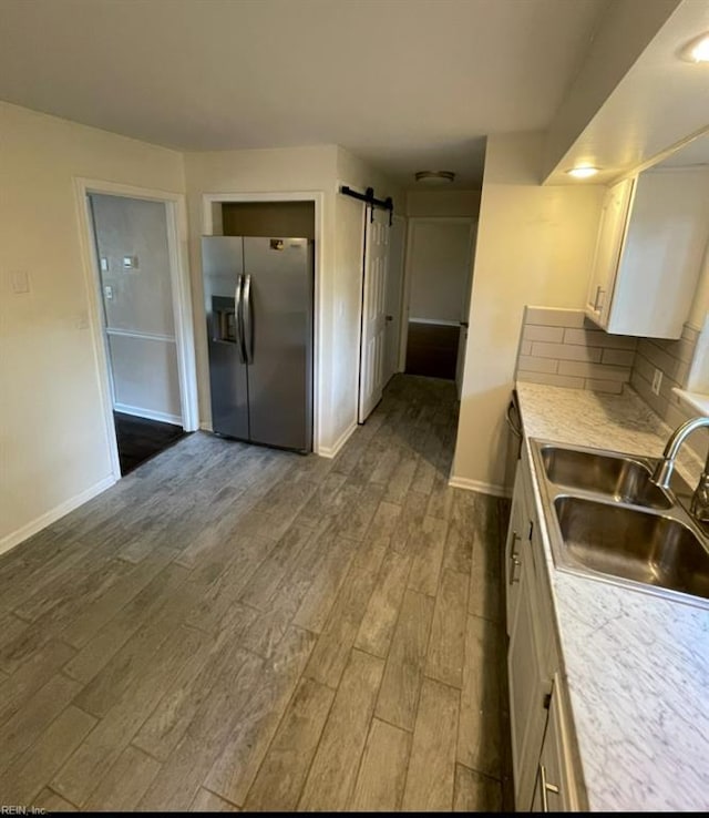 2932 Sunrise Ave, Chesapeake, VA 23324 - kitchen featuring stainless steel refrigerator with ice dispenser, dark wood-type flooring, white cabinetry, a barn door, and light countertops