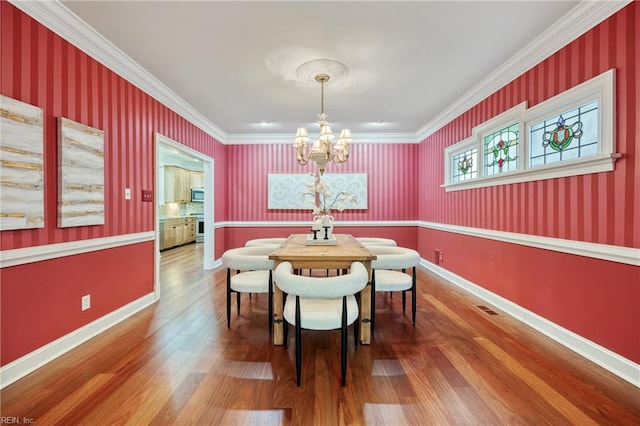 623 London St, Portsmouth, VA 23704 - dining space with a chandelier, wood finished floors, wallpapered walls, and crown molding