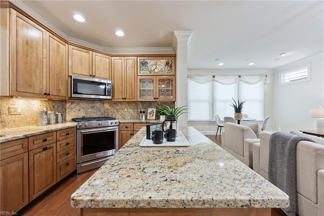 623 London St, Portsmouth, VA 23704 - kitchen featuring appliances with stainless steel finishes, dark wood-style flooring, a kitchen island, light stone counters, and decorative backsplash