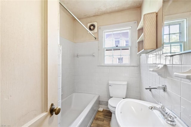 1132 Proctor St, Suffolk, VA 23434 - full bathroom with healthy amount of natural light, shower / bathtub combination, wood finished floors, and tile walls