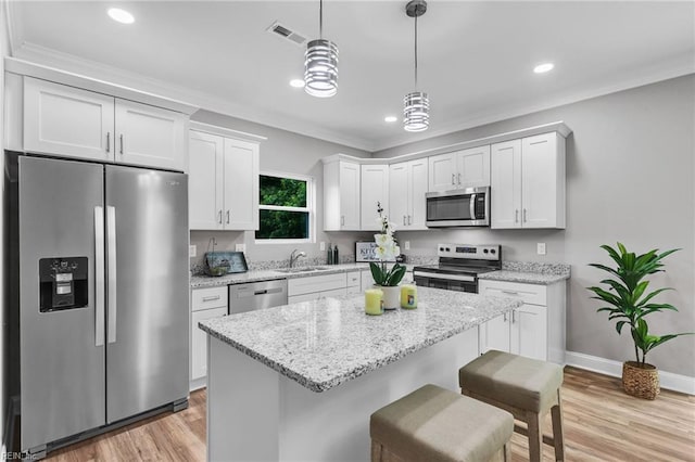 464 Factory St, Suffolk, VA 23434 - kitchen featuring stainless steel appliances, white cabinetry, a kitchen bar, a kitchen island, and pendant lighting