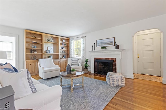 414 Russell St, Portsmouth, VA 23707 - living area featuring light wood-type flooring, a fireplace, and arched walkways