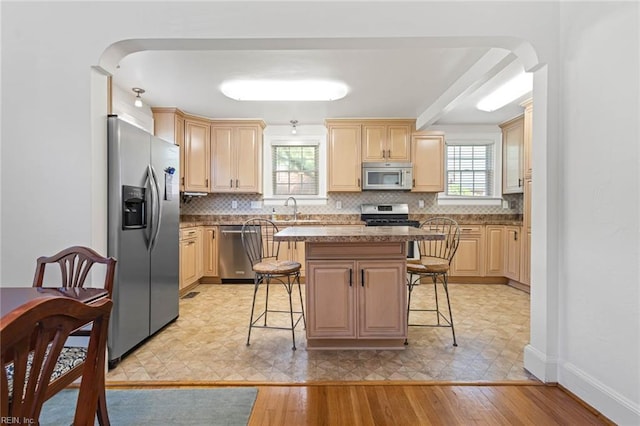 414 Russell St, Portsmouth, VA 23707 - kitchen featuring stainless steel appliances, a breakfast bar, healthy amount of natural light, and backsplash