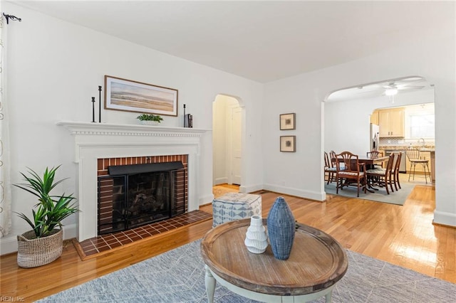 414 Russell St, Portsmouth, VA 23707 - living area with arched walkways, wood finished floors, a ceiling fan, and a fireplace