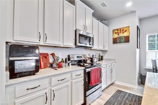 145 Blessing Cir, Suffolk, VA 23434 - kitchen featuring appliances with stainless steel finishes, light wood-style flooring, white cabinetry, light countertops, and recessed lighting