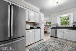 1879 Eastborne Dr, Virginia Beach, VA 23454 - kitchen featuring appliances with stainless steel finishes, light tile patterned floors, dark countertops, and white cabinetry