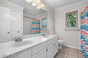 1879 Eastborne Dr, Virginia Beach, VA 23454 - bathroom featuring healthy amount of natural light, double vanity, ornamental molding, tile patterned flooring, and curtained shower
