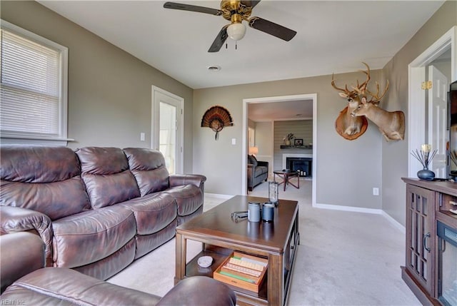 215 Lisbon Dr, Newport News, VA 23601 - carpeted living room featuring a fireplace, ceiling fan, and plenty of natural light