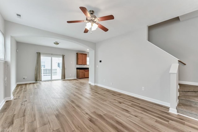 923 Hill St, Chesapeake, VA 23324 - unfurnished living room featuring light wood finished floors, a ceiling fan, arched walkways, and stairs