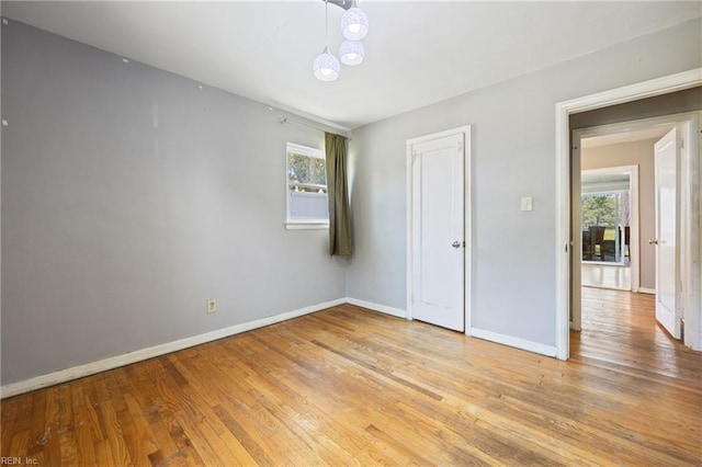 556 Summers Dr, Norfolk, VA 23509 - unfurnished bedroom featuring light wood-style flooring and a chandelier
