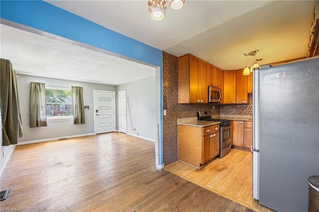 556 Summers Dr, Norfolk, VA 23509 - kitchen featuring appliances with stainless steel finishes, brown cabinets, light wood-style floors, and backsplash