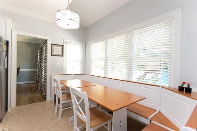 108 Sunrise Bluff Ct, Smithfield, VA 23430 - dining area with healthy amount of natural light, ornamental molding, light tile patterned floors, vaulted ceiling, and a wainscoted wall