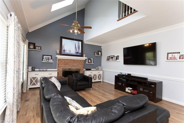 108 Sunrise Bluff Ct, Smithfield, VA 23430 - living room featuring wood finished floors, a skylight, ceiling fan, a fireplace, and crown molding