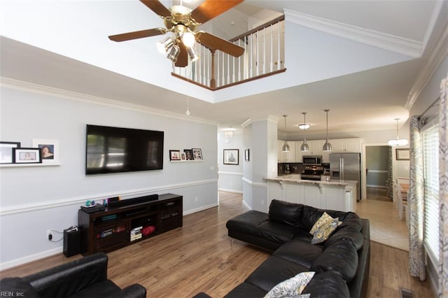 108 Sunrise Bluff Ct, Smithfield, VA 23430 - living room with ceiling fan, crown molding, light wood-type flooring, and a towering ceiling