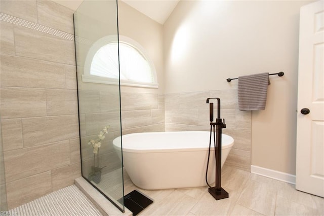 108 Sunrise Bluff Ct, Smithfield, VA 23430 - bathroom featuring a walk in shower, tile patterned flooring, a soaking tub, tile walls, and lofted ceiling