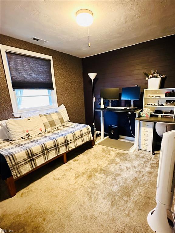 1204 Holly Ave, Chesapeake, VA 23324 - carpeted bedroom with a desk, a textured ceiling, and wood walls