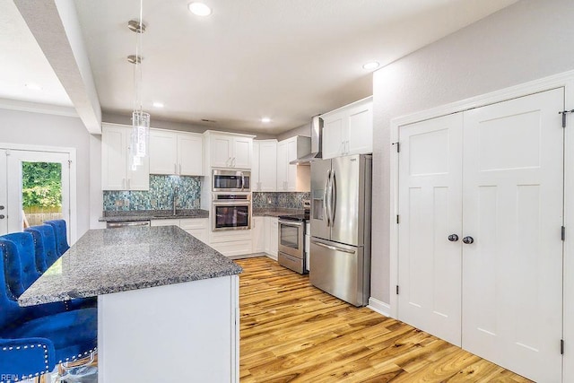 1161 Bells Mill Rd, Chesapeake, VA 23322 - kitchen featuring stainless steel appliances, wall chimney exhaust hood, light wood-type flooring, decorative backsplash, and white cabinetry