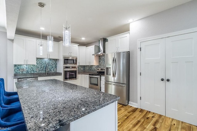 1161 Bells Mill Rd, Chesapeake, VA 23322 - kitchen with appliances with stainless steel finishes, wall chimney exhaust hood, backsplash, light wood finished floors, and recessed lighting