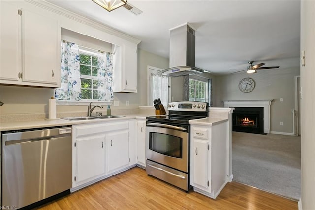 102 Saddle Dr, Newport News, VA 23602 - kitchen with appliances with stainless steel finishes, island exhaust hood, light countertops, a peninsula, and white cabinetry