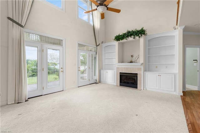 1938 Lancing Crest Ln, Chesapeake, VA 23323 - unfurnished living room with ceiling fan, a tiled fireplace, a towering ceiling, and carpet floors