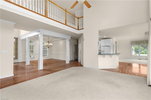 1938 Lancing Crest Ln, Chesapeake, VA 23323 - unfurnished living room with carpet, a chandelier, a ceiling fan, a towering ceiling, and wood finished floors