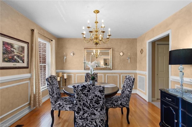 203 Vixen Ct, Yorktown, VA 23693 - dining space featuring a chandelier, light wood finished floors, wainscoting, and a decorative wall