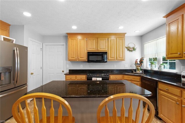 203 Vixen Ct, Yorktown, VA 23693 - kitchen with black appliances, a kitchen bar, recessed lighting, dark stone counters, and a textured ceiling