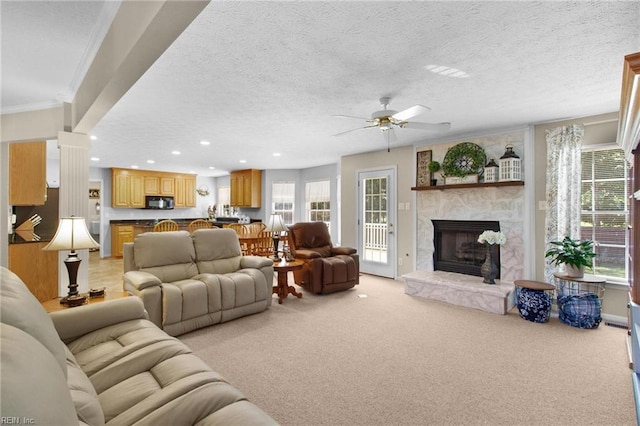 203 Vixen Ct, Yorktown, VA 23693 - living area featuring healthy amount of natural light, light colored carpet, a ceiling fan, a stone fireplace, and a textured ceiling