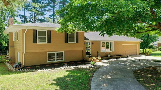 205 Ridgeland Dr, Smithfield, VA 23430 - tri-level home with a garage, a chimney, driveway, brick siding, and a front yard