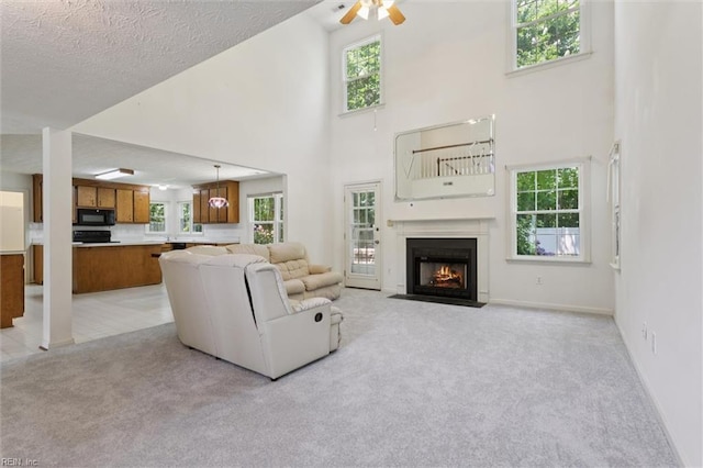 104 Hounds Chase Chase, Yorktown, VA 23693 - living area with light colored carpet, a high ceiling, a ceiling fan, a fireplace with flush hearth, and plenty of natural light