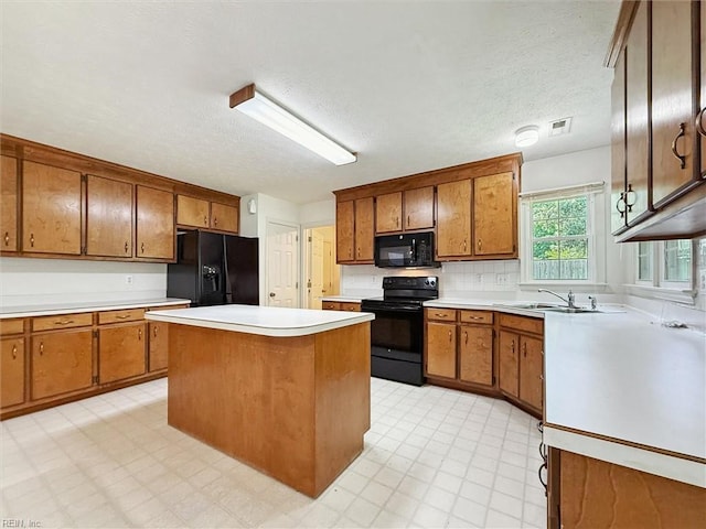 104 Hounds Chase Chase, Yorktown, VA 23693 - kitchen featuring black appliances, brown cabinets, light countertops, a textured ceiling, and a center island