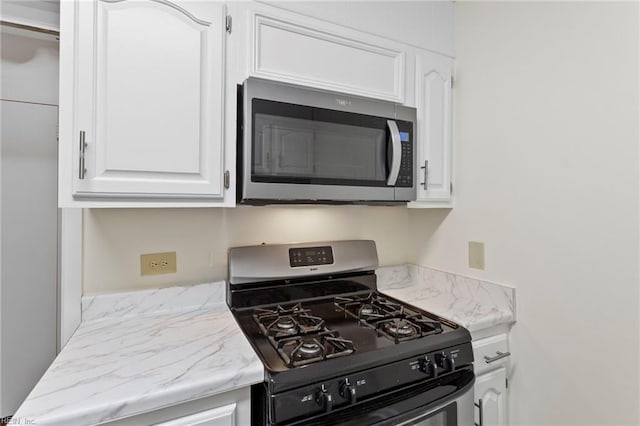 7320 Glenroie Ave Unit 5G, Norfolk, VA 23505 - kitchen featuring gas stove, stainless steel microwave, and white cabinets