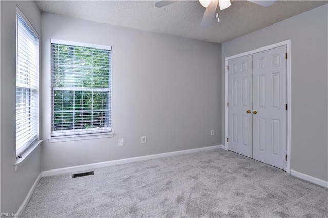 3957 Driftwood Way, Williamsburg, VA 23188 - unfurnished bedroom featuring carpet flooring, a textured ceiling, a closet, and a ceiling fan