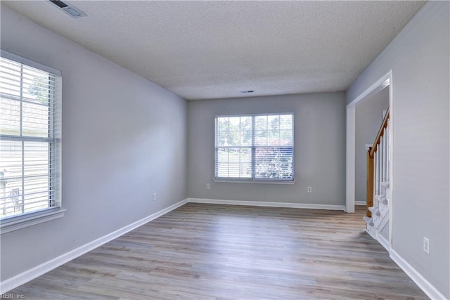 3957 Driftwood Way, Williamsburg, VA 23188 - empty room featuring healthy amount of natural light, a textured ceiling, and wood finished floors