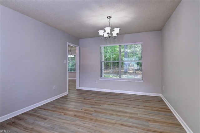 3957 Driftwood Way, Williamsburg, VA 23188 - spare room featuring a textured ceiling, a chandelier, and wood finished floors